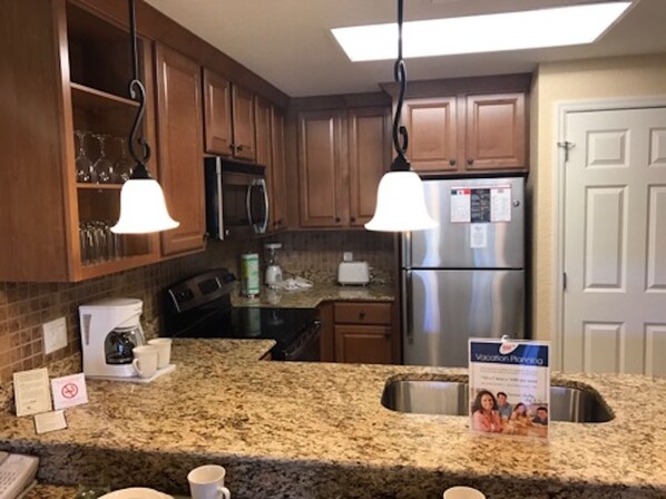 Enjoy cooking in this well-equipped kitchen with a refrigerator, coffee maker, and ample counter space.