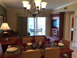 Enjoy meals in this dining area with a table for four, featuring a chandelier and sliding glass door to an outdoor patio.