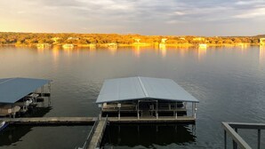 A calm lake with a dock and a covered boat house. - Fun N The Sun  Lake Travis Resort 105 (Spicewood)