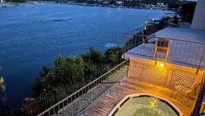 A wooden deck with a hot tub and a view of the sea. - Fun N The Sun  Lake Travis Resort 105 (Spicewood)