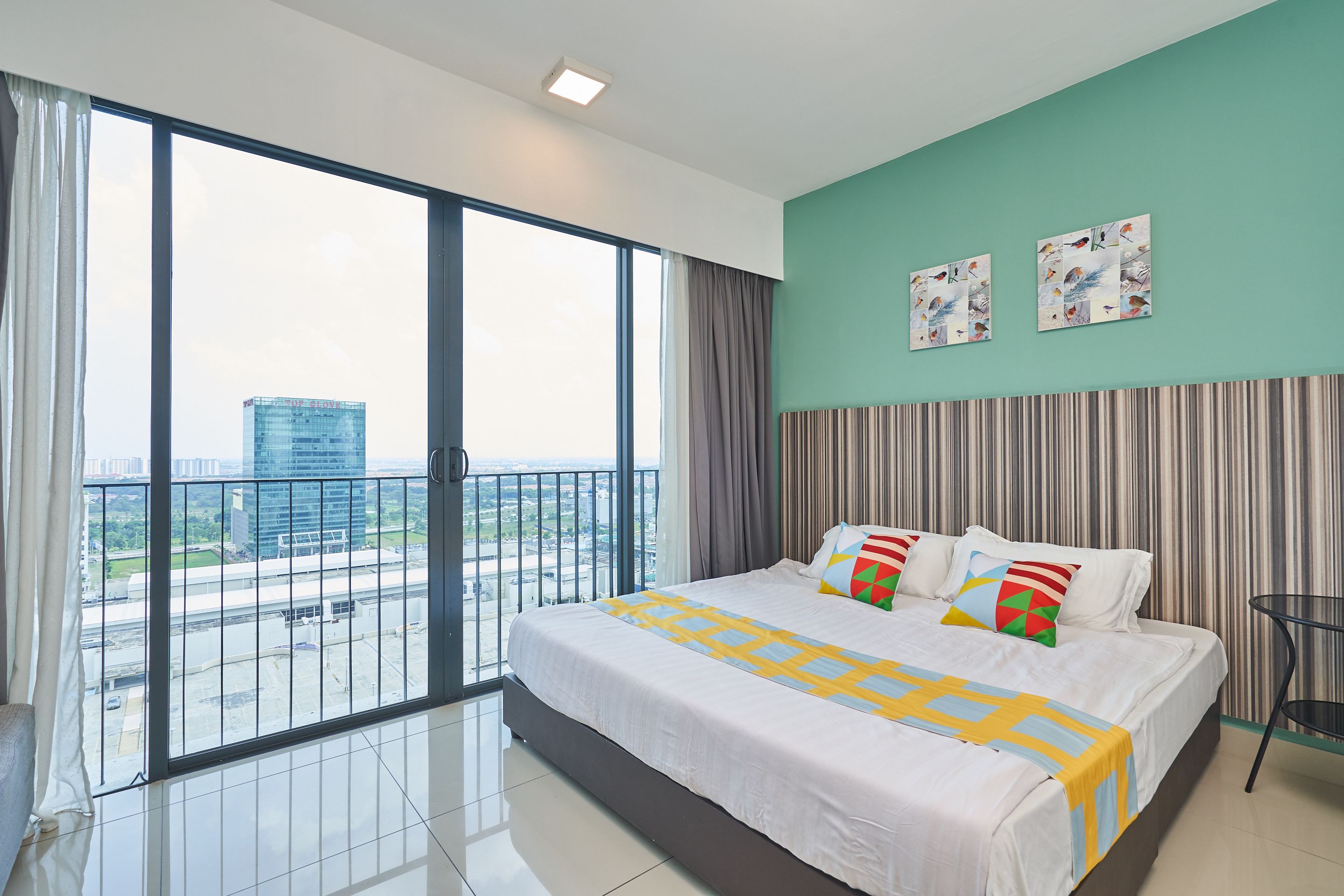 A modern hotel room with a large bed, a view of the city, and a balcony.
