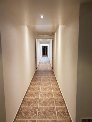 Stylish corridor with patterned tile floor and double doors leading to a room.