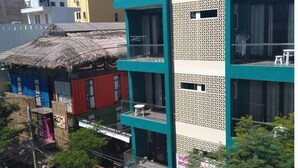 A multi-story building with a modern design, featuring balconies and large windows. - Vuon Hong Hotel & Apartments (Da Nang)