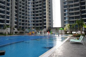 A swimming pool with a water slide and a children's play area.