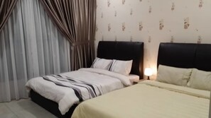 A hotel room with two beds, a nightstand, and a lamp.