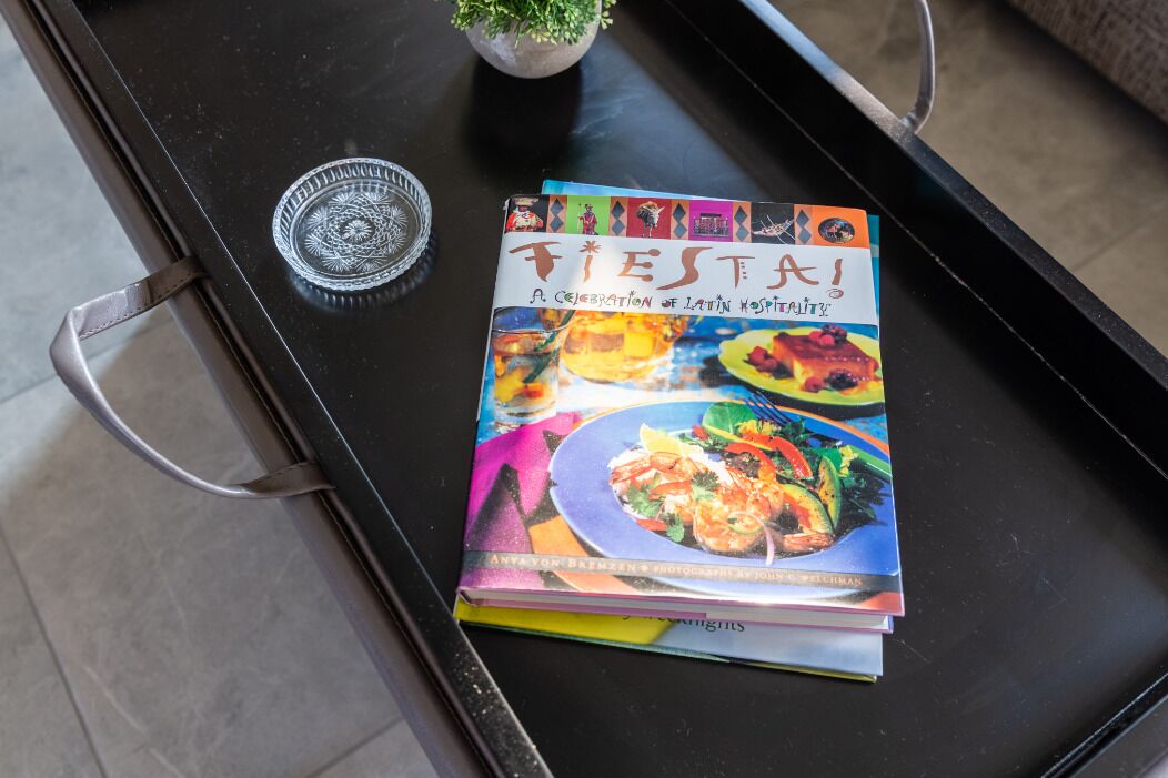 A stack of books titled 'Fiesta! A Celebration of Latin Hospitality' on a black tray.
