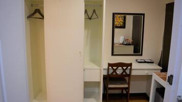 Quarto compacto com guarda-roupa, escrivaninha, cadeira e espelho.