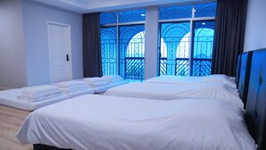 A hotel room with two beds, a white door, and large windows with a view of a balcony. - Cozy Villa Genting Highlands (Genting Highlands)