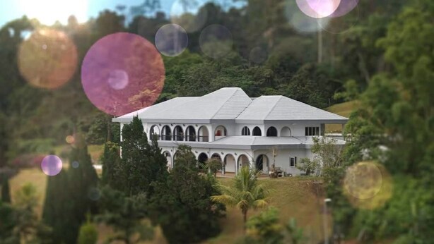 A large, white building with multiple arches and a sloped roof, surrounded by lush greenery. - Cozy Villa Genting Highlands (Genting Highlands)