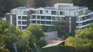 A multi-story building with a modern architectural design, featuring balconies and large windows.