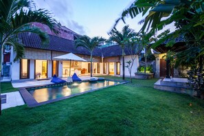 A modern house with a swimming pool, outdoor seating, and a well-maintained garden. - Casaluna Villa (Seminyak)