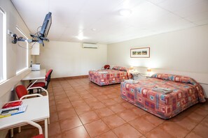 A small, clean room with two beds, a desk, a chair, and a TV mounted on the wall. - Leichhardt Hotel Motel (Cloncurry)
