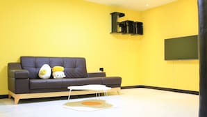 Una sala de estar moderna con un sofá marrón oscuro, una mesa de centro blanca y dos almohadones decorativos.