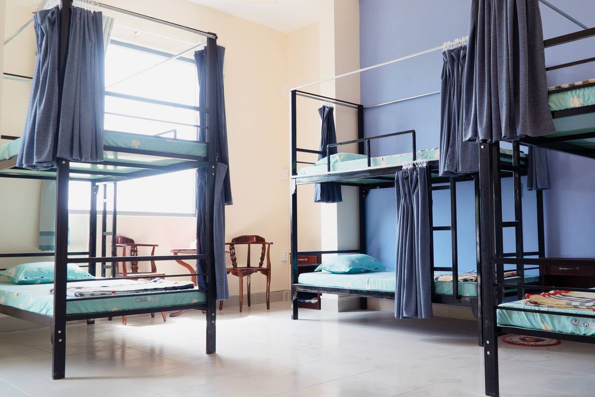 Une chambre de dortoir avec des lits superposés, une chaise et une petite table.