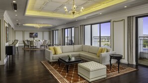 Un salon spacieux avec un grand canapé d’angle, une table basse et un coin repas à l’arrière-plan.
