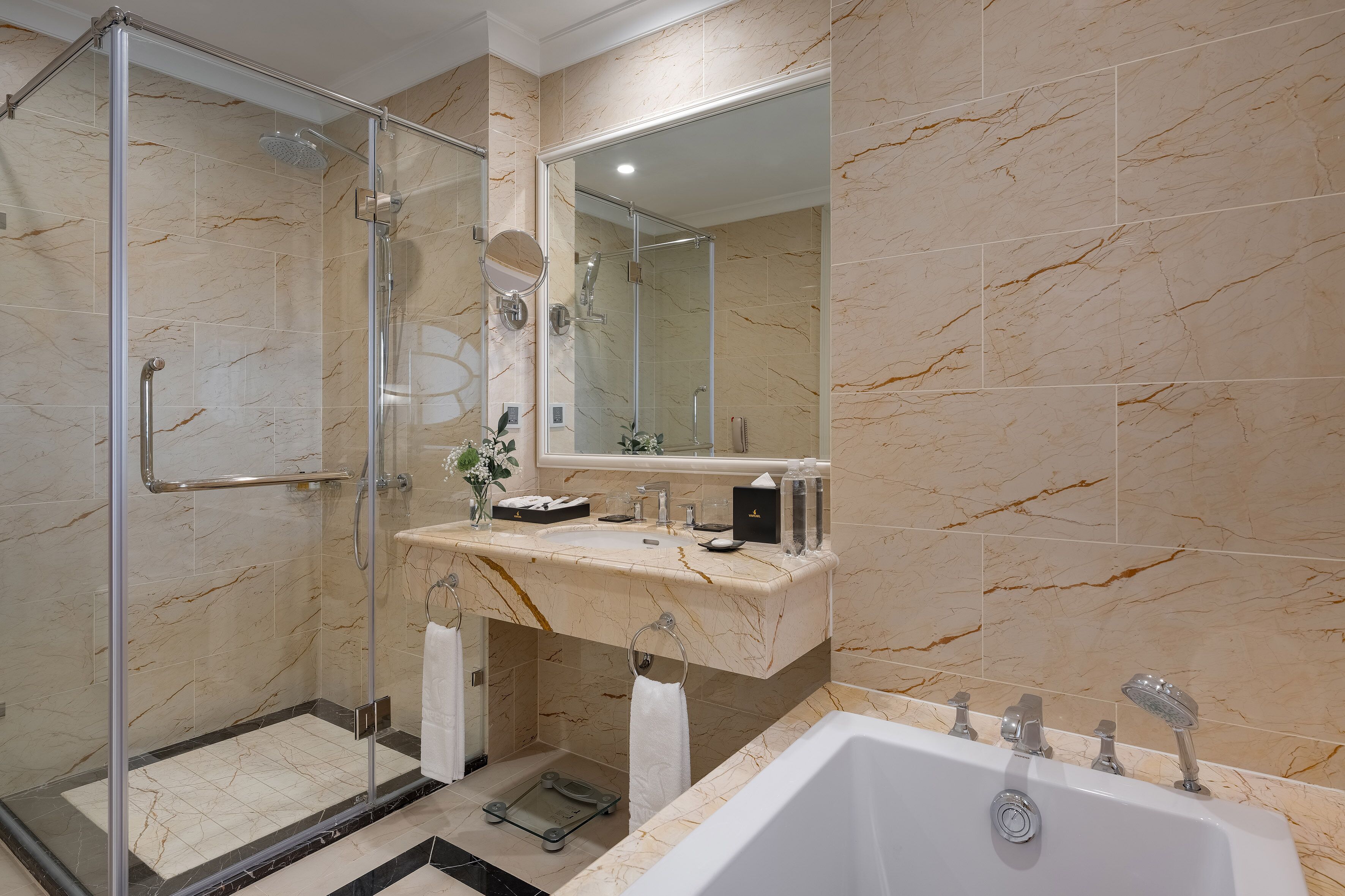 Une salle de bain moderne avec une douche à l’italienne, un meuble-lavabo en marbre et une grande baignoire.