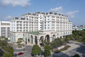 A multi-story hotel with a symmetrical facade, large windows, and a central entrance. - Meliá Vinpearl Hai Phong Rivera (Hai Phong)