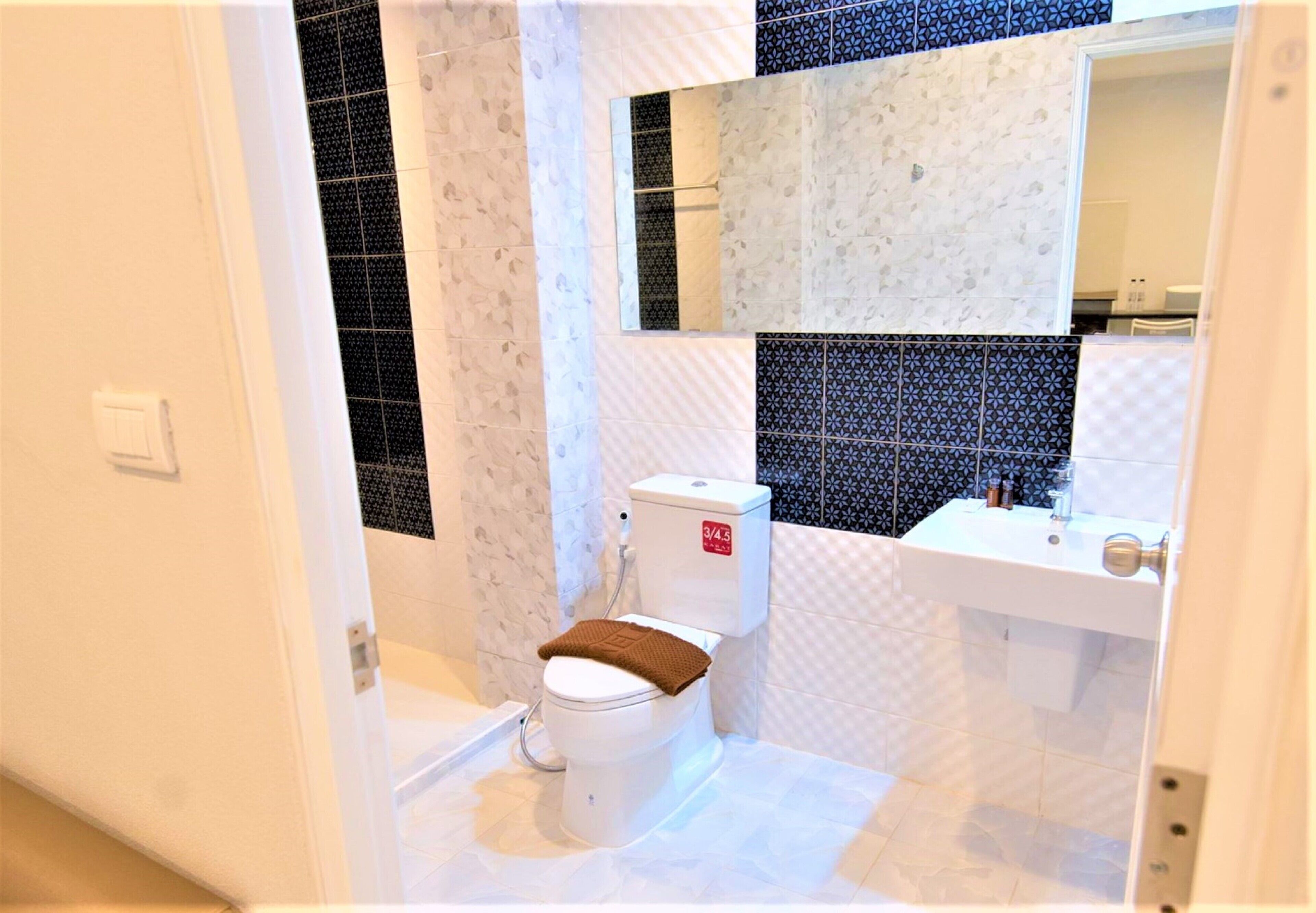 A bathroom with a white toilet, a sink, and a mirror.
