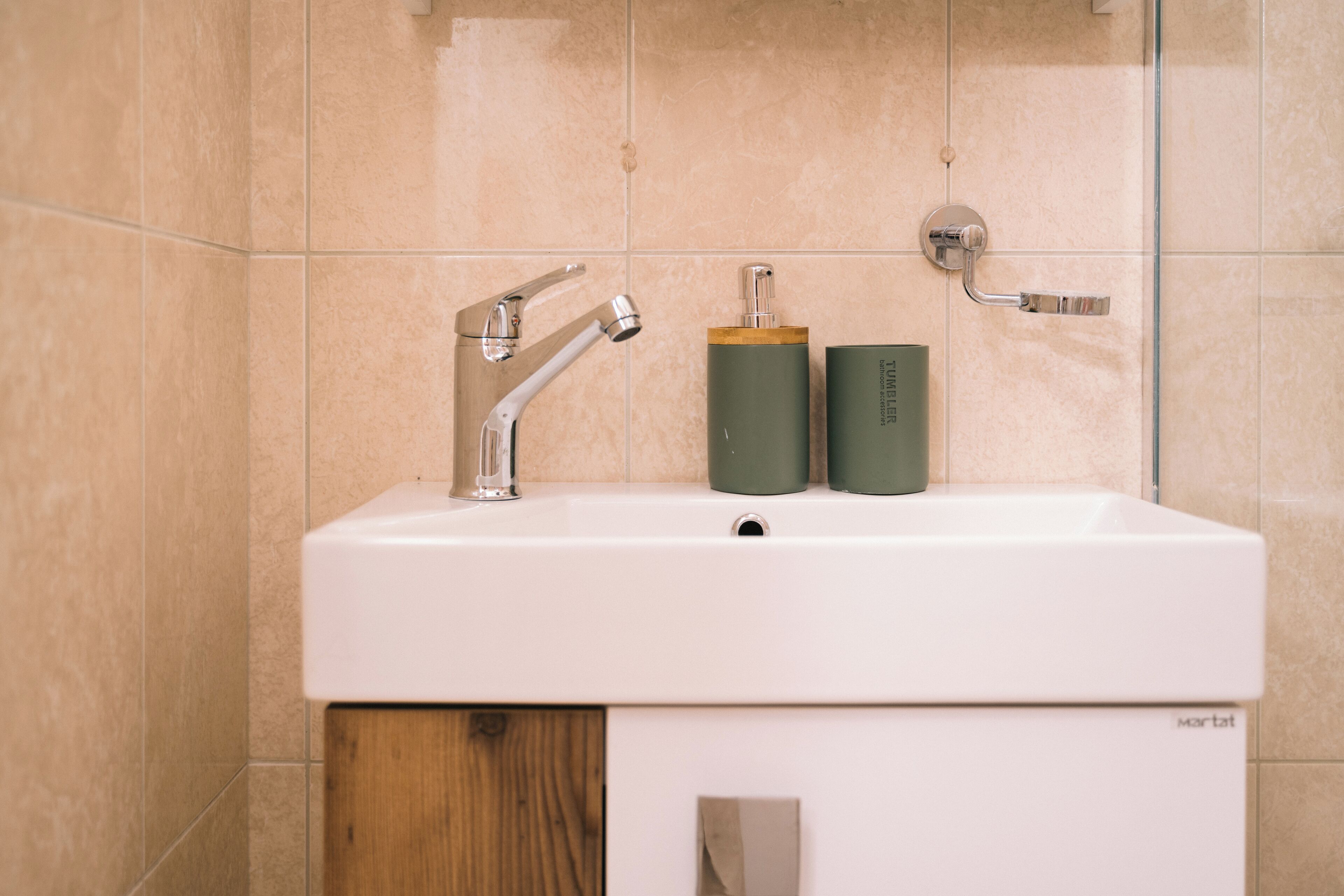 Ein Badezimmer mit einem weißen Waschbecken, zwei grünen Flaschen und einer weißen Toilette.