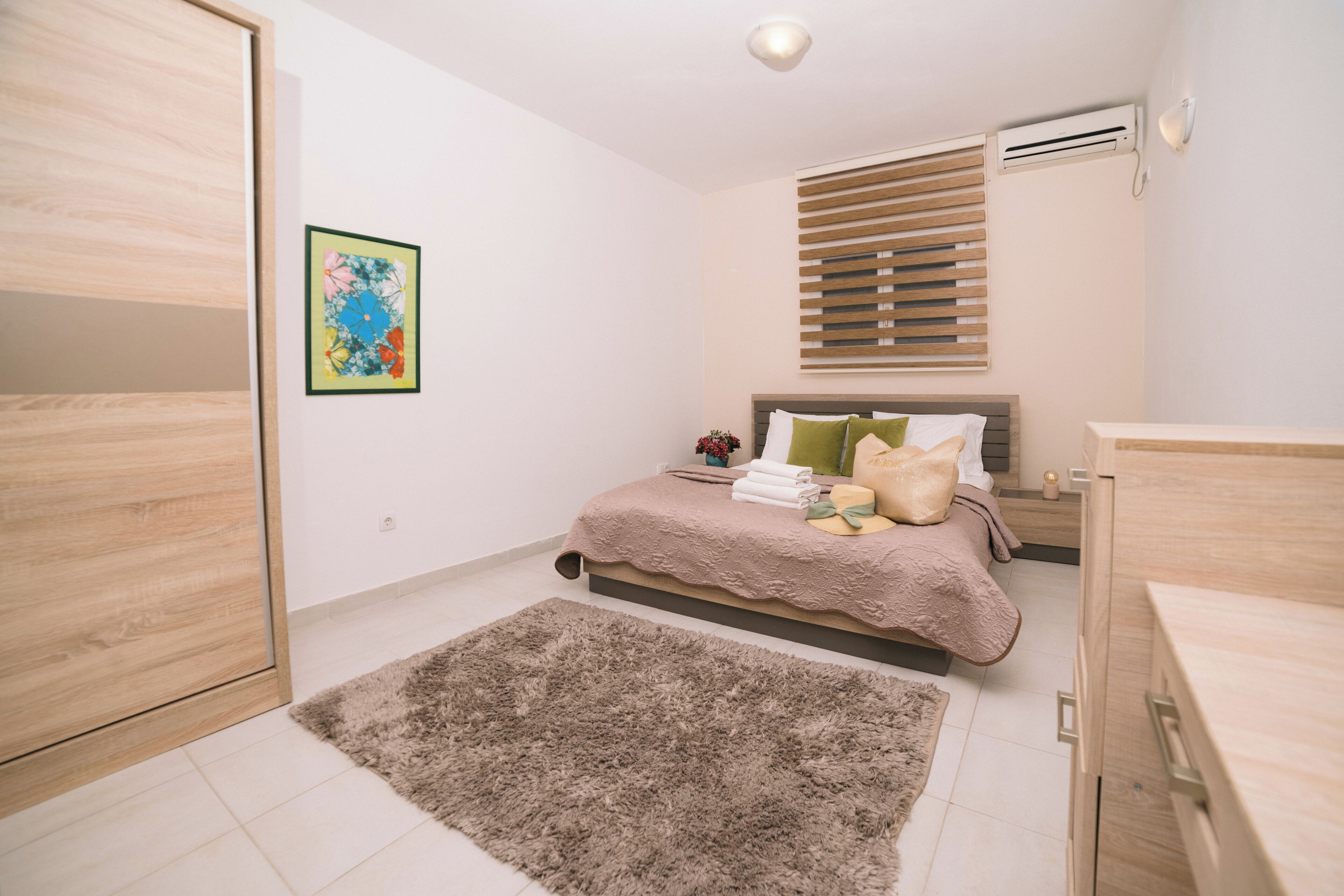 Een slaapkamer met een bed, nachtkastje en een airconditioning.