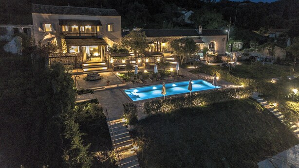 Un'ampia casa con piscina, area salotto esterna e un patio ben illuminato.