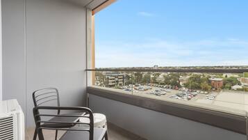 Ein Balkon mit Blick auf einen Parkplatz und Gebäude.