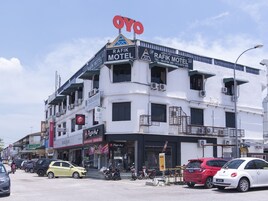 A building with a sign for 'Rafik Motel' and 'Pizza Hut' on the ground floor.