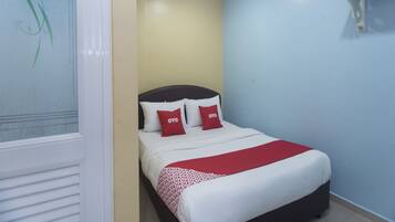 A bedroom with a bed, a red and white bedspread, and two red pillows with "OYO" text.