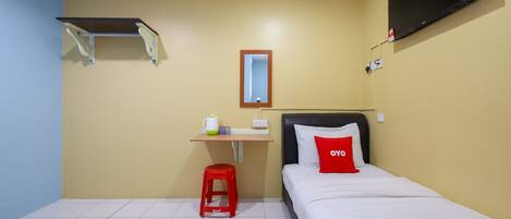 Habitación de hotel con dos camas, un televisor montado en la pared, una mesita con una taza y un taburete rojo.
