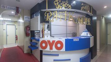 A reception desk with a sign reading "OYO" and "Reception".