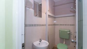 Un baño con lavamanos, inodoro y ducha.