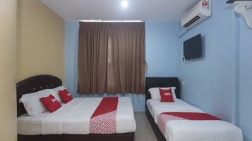 Habitación de hotel con dos camas, televisión, aire acondicionado y ventana con cortinas.