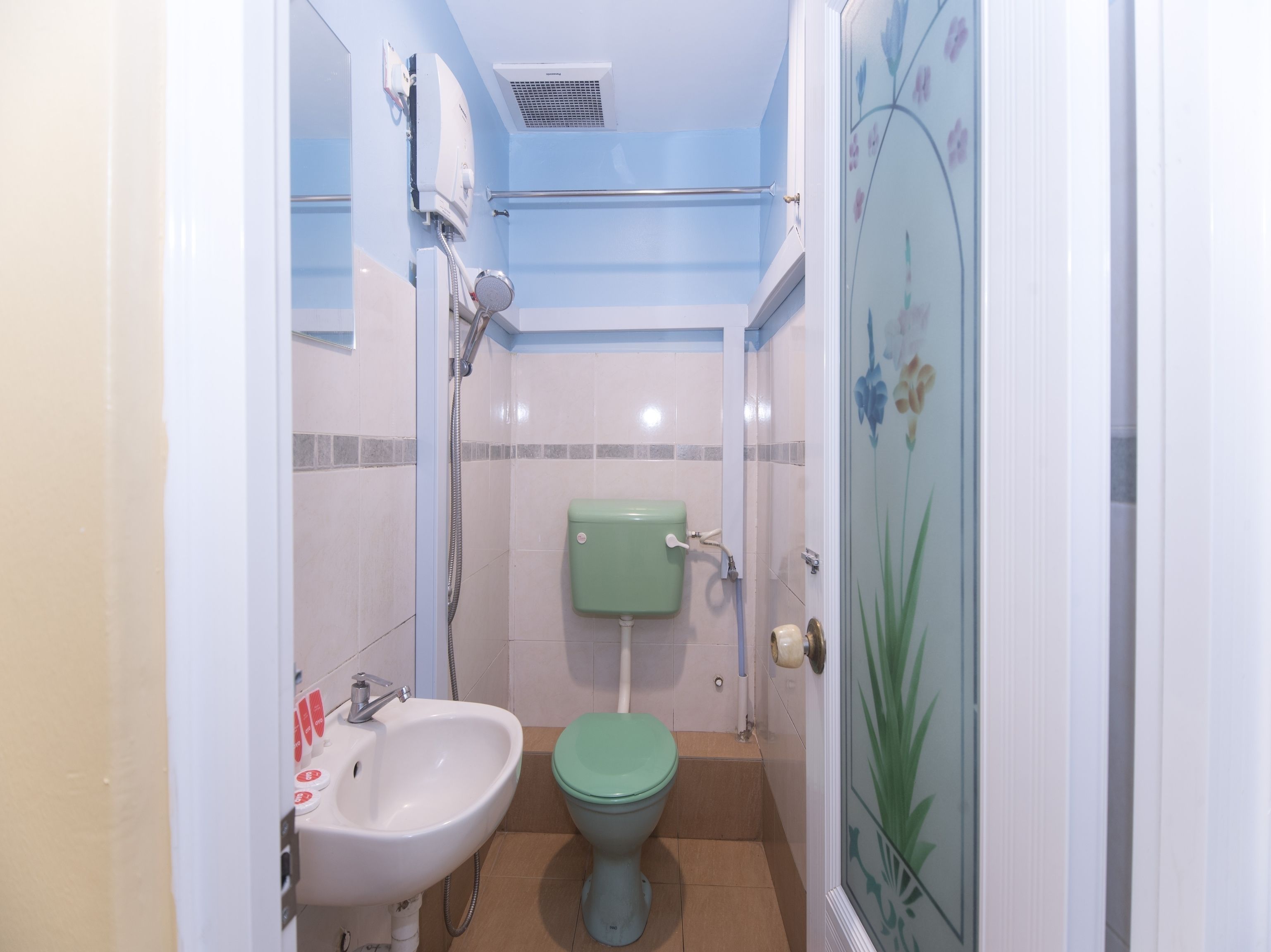 A small bathroom with a sink, toilet, and shower.