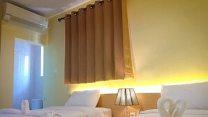 Ein Hotelzimmer mit zwei Betten, einer Nachttischlampe und einem Vorhang.