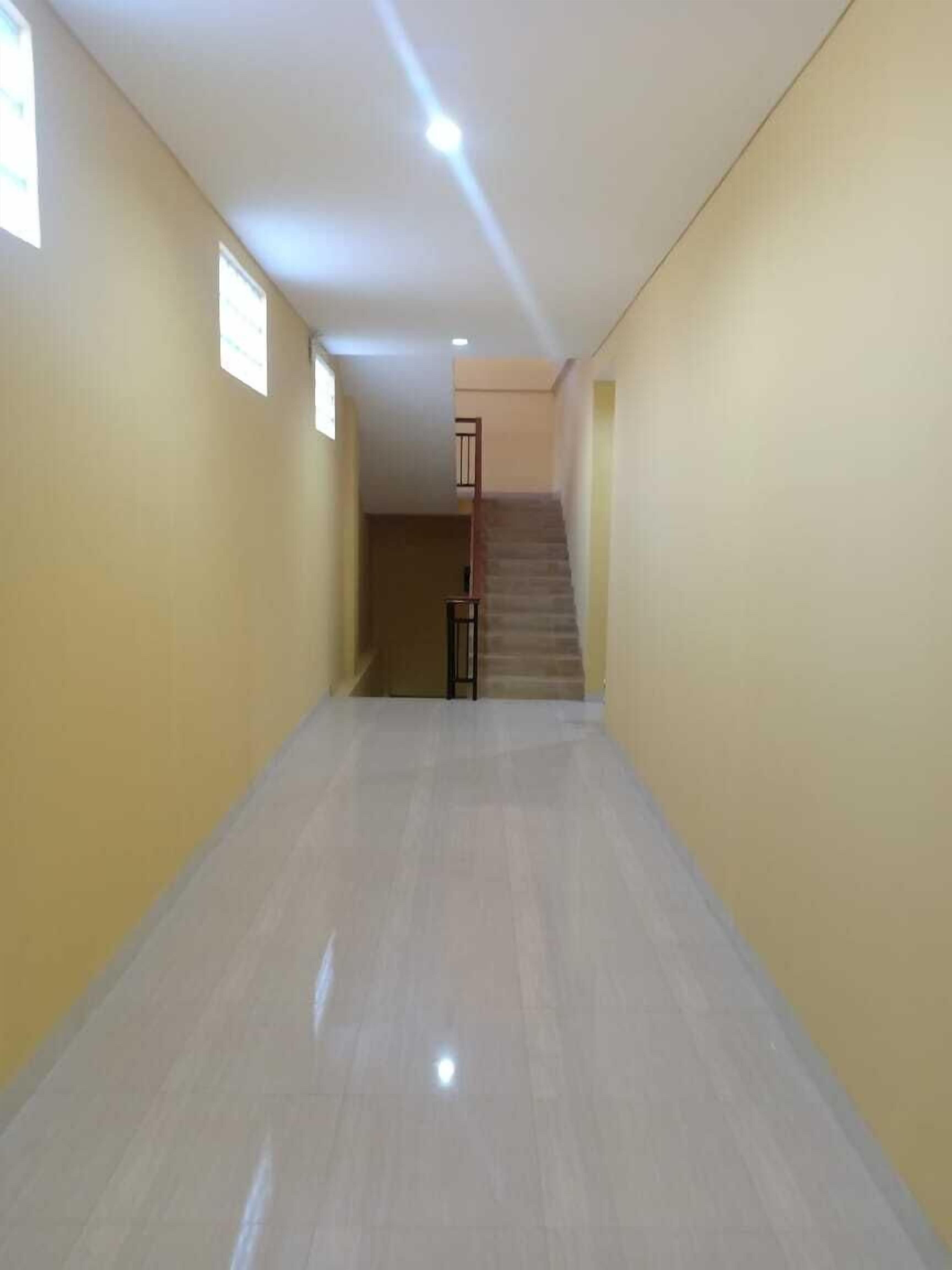 Un pasillo con una escalera que sube a un piso superior.