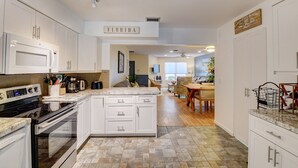 A kitchen with white cabinetry, a central island, and a sign reading "FLORIDA". - Gorgeous Downtown Delray Beach Cottage (Delray Beach)