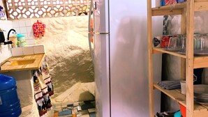 Eine Küche mit Kühlschrank, Spüle und einer Holzausstattung mit Küchenutensilien.