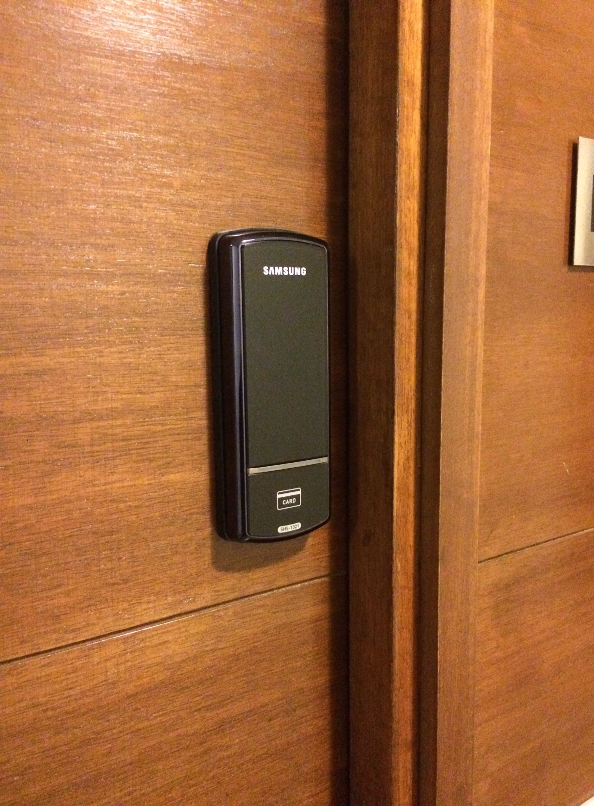 Un lector de tarjetas Samsung fijado en una puerta de madera.
