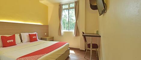 A hotel room with a bed, a desk, and a chair.