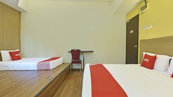 A hotel room with two beds, a desk, and a chair.