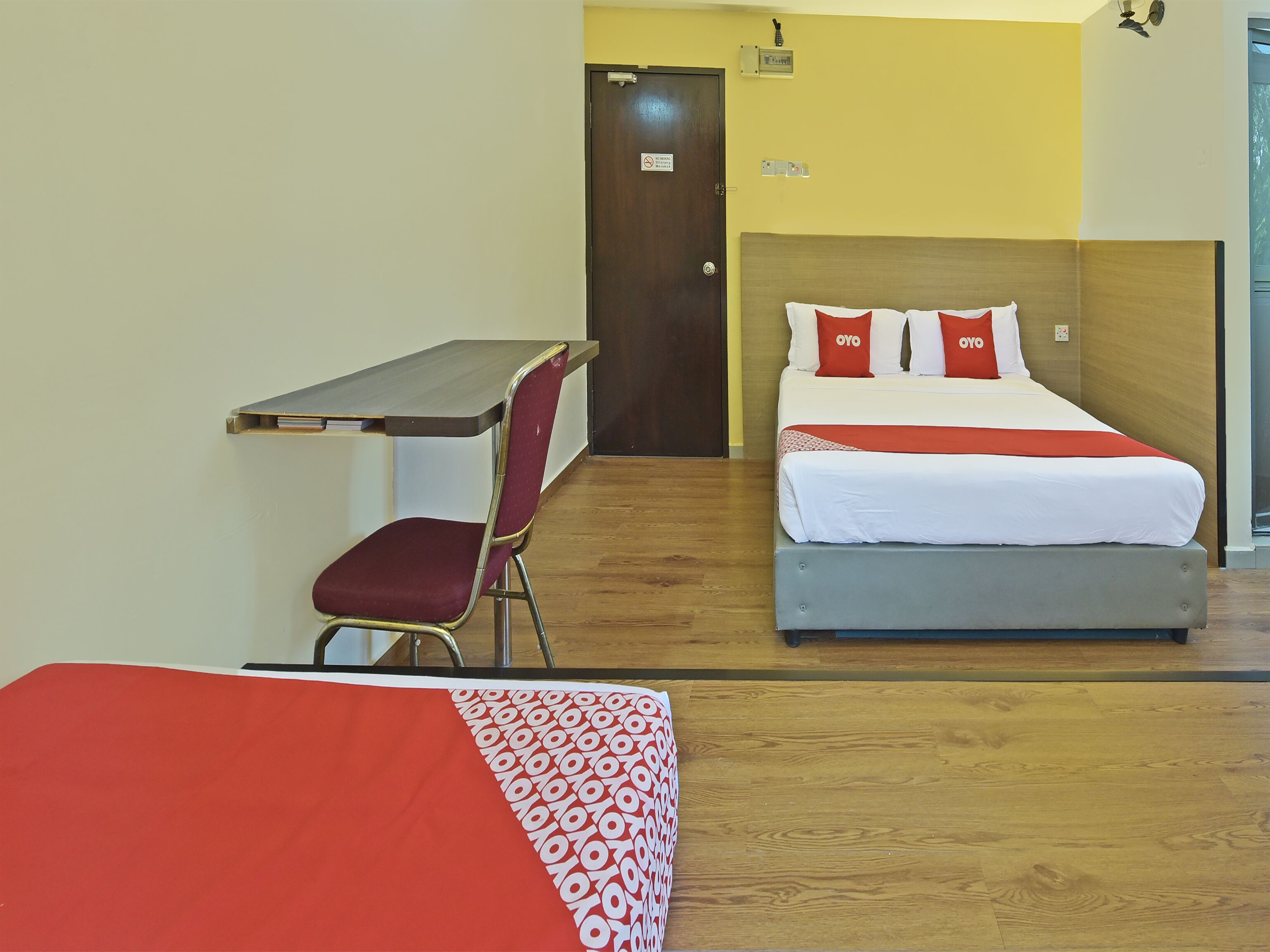 A hotel room with a bed, a desk, and a chair.