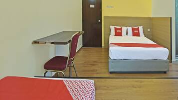 A hotel room with a bed, a desk, and a chair.