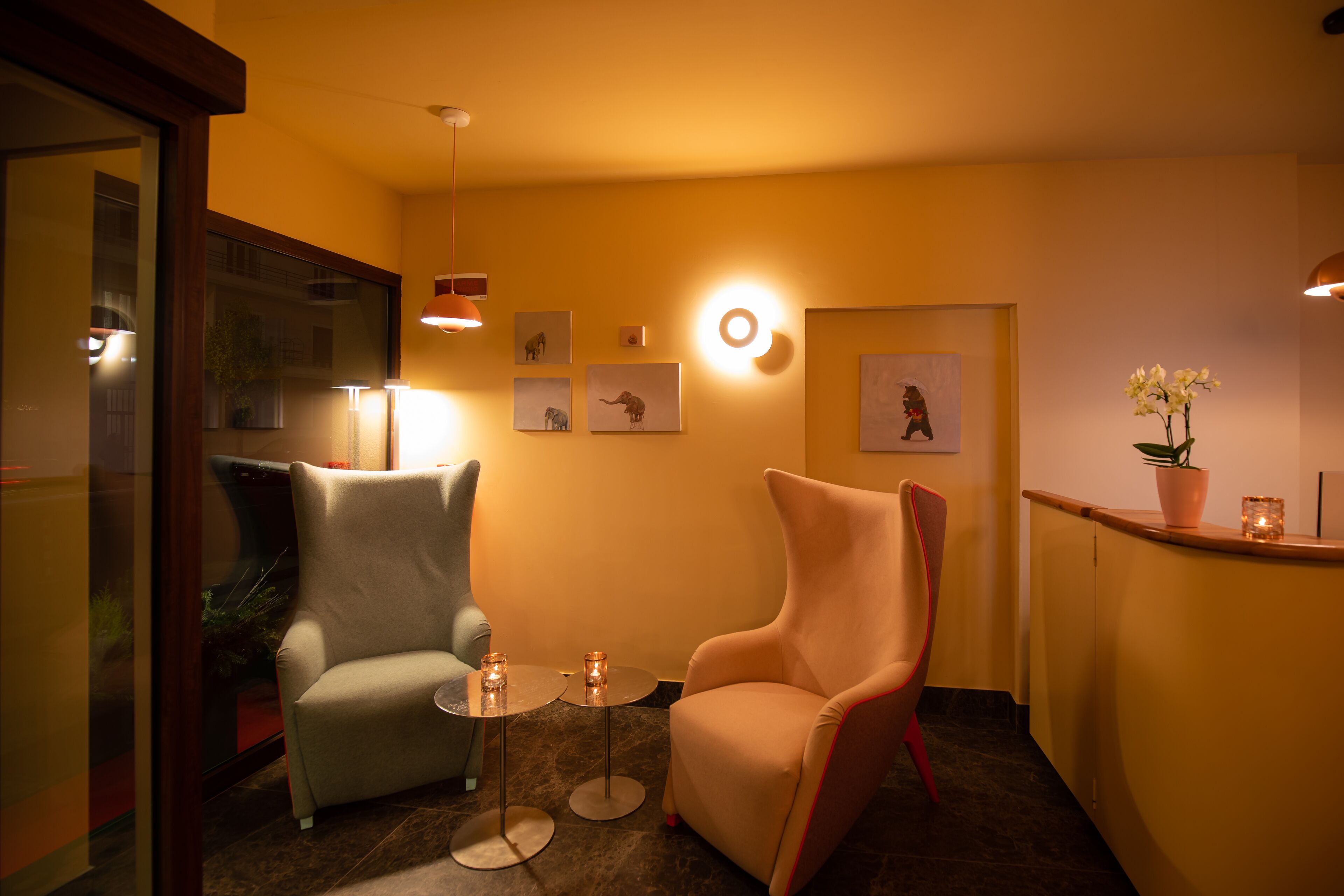 Una habitación con dos sillones, una mesita y un mostrador de recepción.