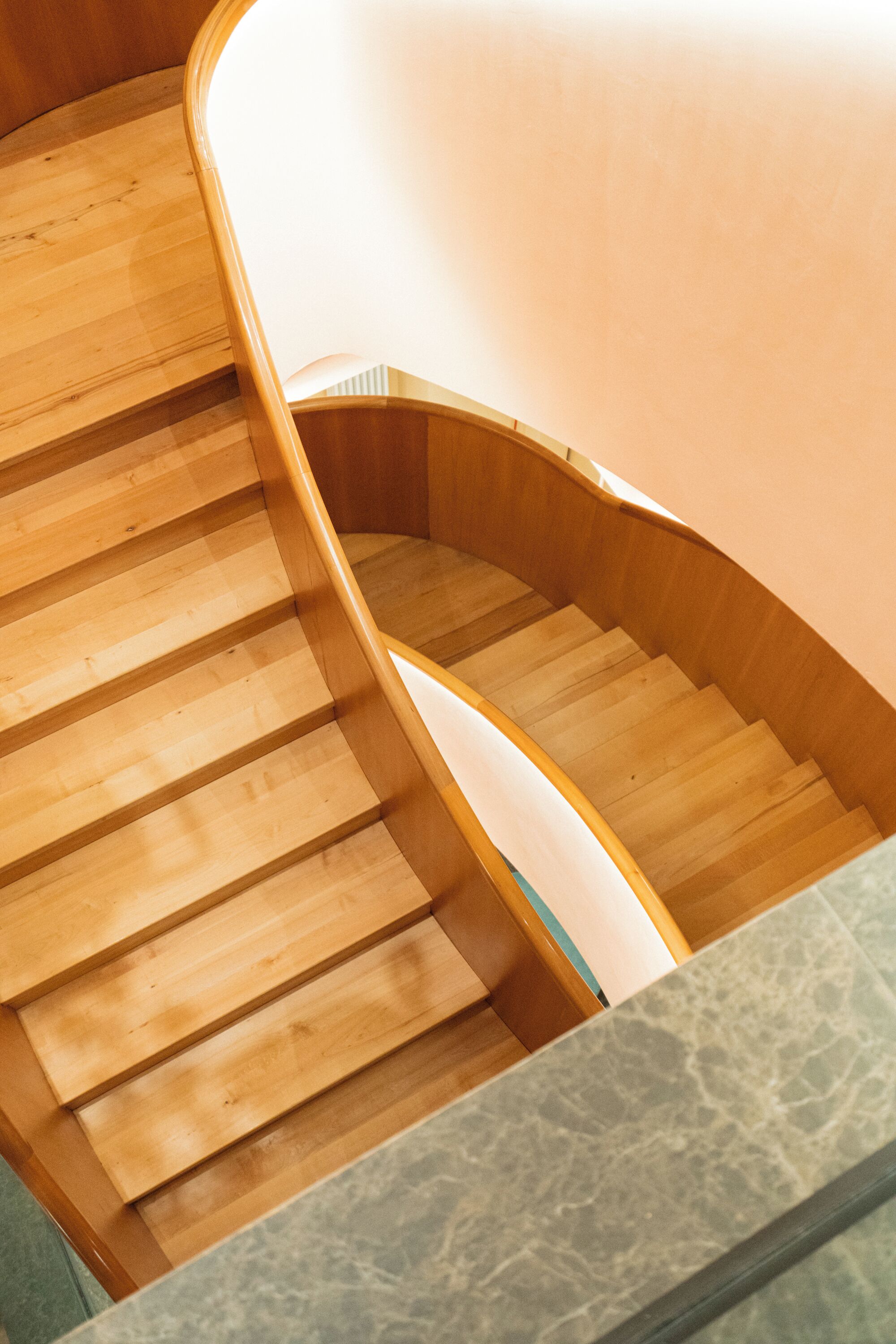 Eine hölzerne Wendeltreppe, die zu einer höheren Etage führt.