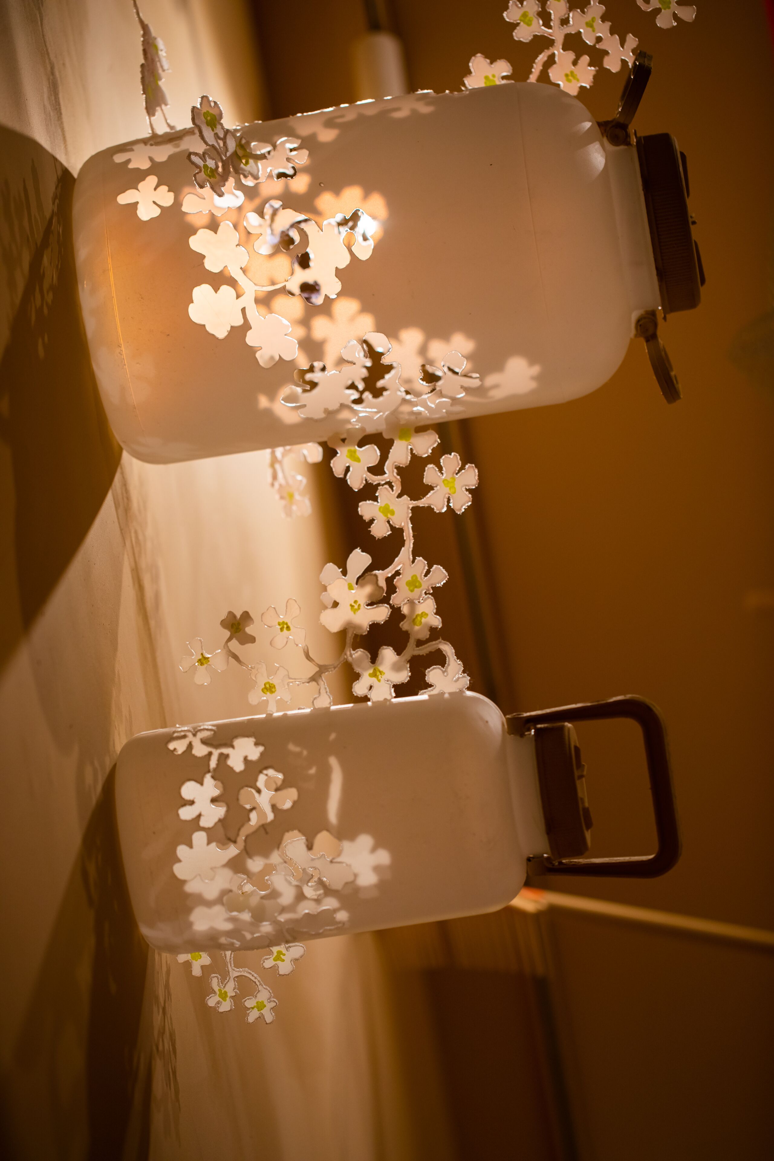 Twee drinkflessen met bloemendesign en metalen sluitingen.