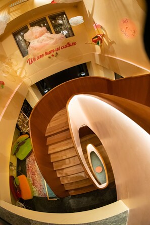 A spiral staircase with a wooden finish and a handrail, leading to a lower level. - Omama Hotel (Aosta)
