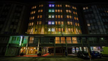 Un hotel con una fachada particular que presenta letras iluminadas que deletrean el nombre.
