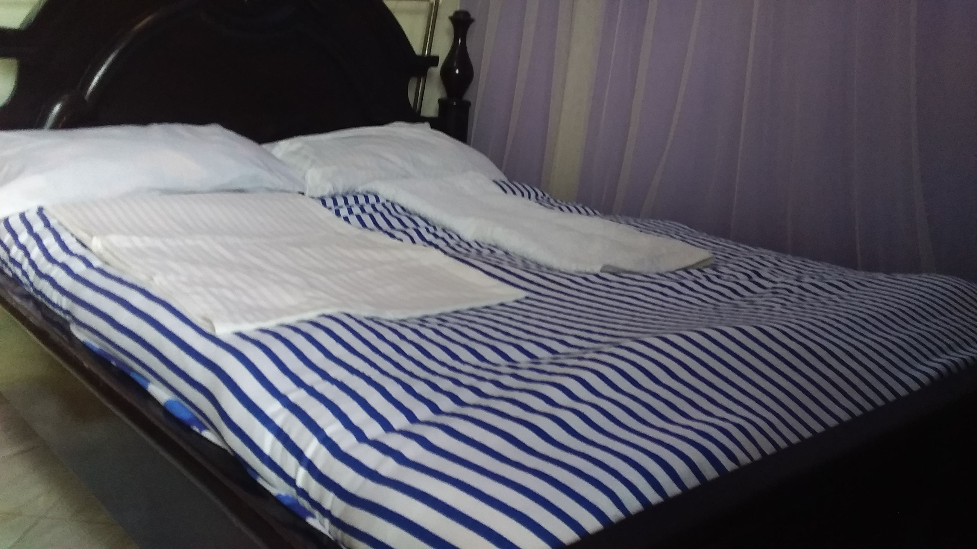 Ein Bett mit gestreifter Bettdecke und Kissen.