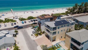 A coastal hotel with a beach view, multiple parking spaces, and a pool area. - 102 6th St S-downstairs 3 Bedroom Home (Bradenton Beach)
