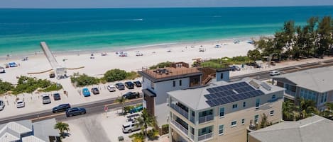 Ein Hotel an der Küste mit Blick auf den Strand, mehreren Parkplätzen und einem Poolbereich.